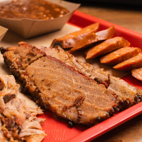 Double D's Southern BBQ platter with sliced brisket, pulled pork, sausage, and baked beans.