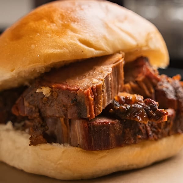 Close-up of a Double D's Southern BBQ pulled pork sandwich on a soft bun.